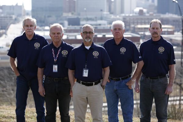 Cold Case Task Force group photo on hill with city in background.