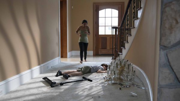 Max Shacknai at bottom of stairs next to broken chandelier / Rebecca running into room