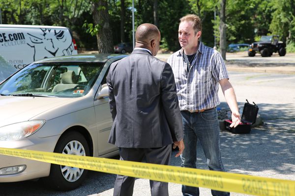 Two people talk on a crime scene.